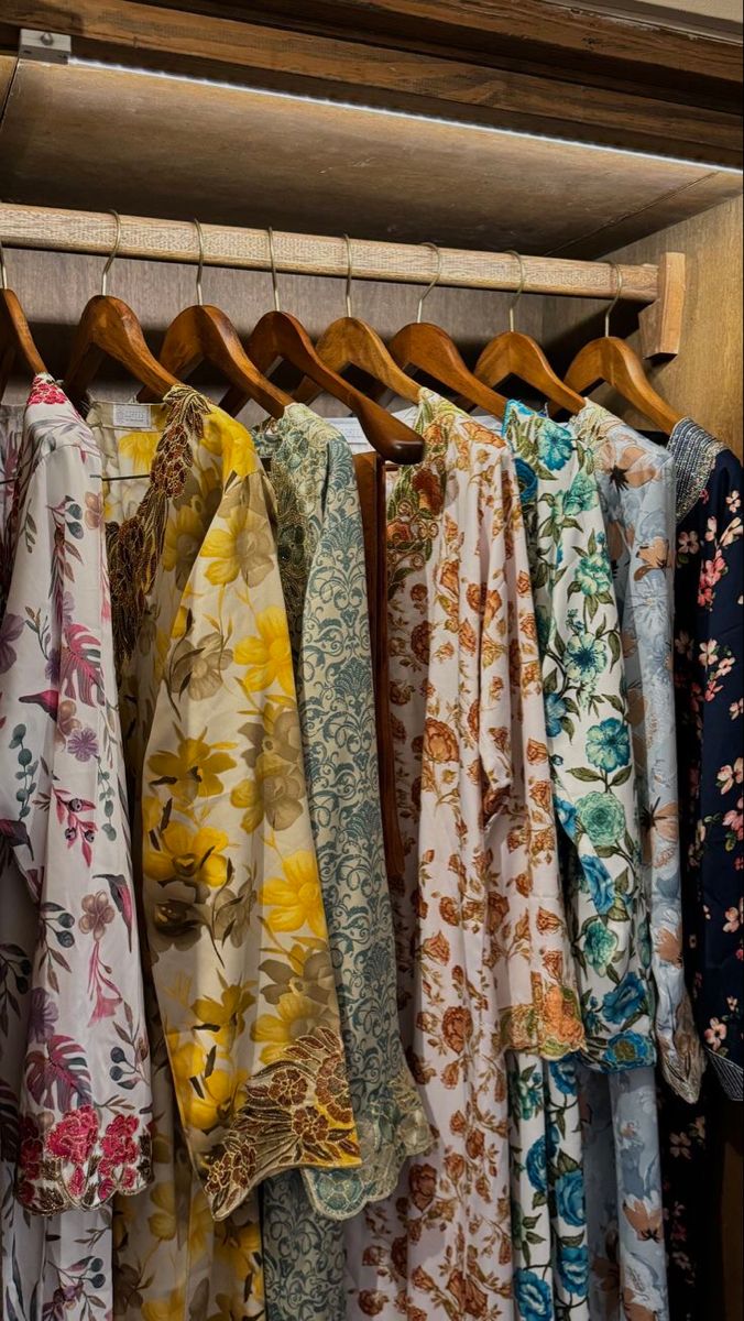 Vintage floral dresses hanging in wooden wardrobe